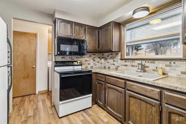 kitchen featuring light wood finished floors, electric range, a sink, decorative backsplash, and black microwave