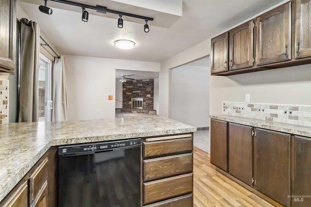 kitchen with a ceiling fan, a peninsula, light countertops, black dishwasher, and backsplash