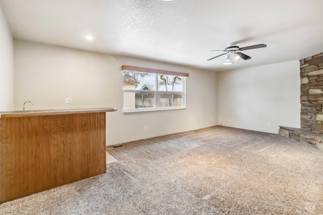 unfurnished living room featuring carpet floors and ceiling fan