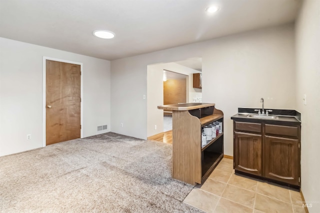 kitchen featuring visible vents, a sink, recessed lighting, light tile patterned floors, and light colored carpet