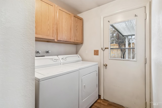 laundry room featuring cabinet space, washing machine and dryer, and wood finished floors