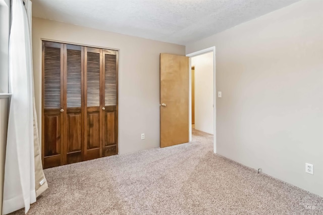 unfurnished bedroom with a closet, carpet flooring, and a textured ceiling