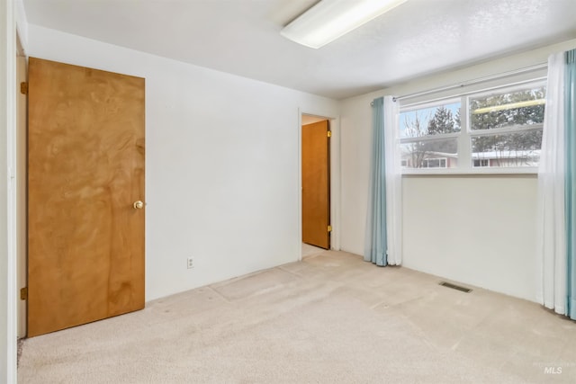 spare room featuring visible vents and carpet