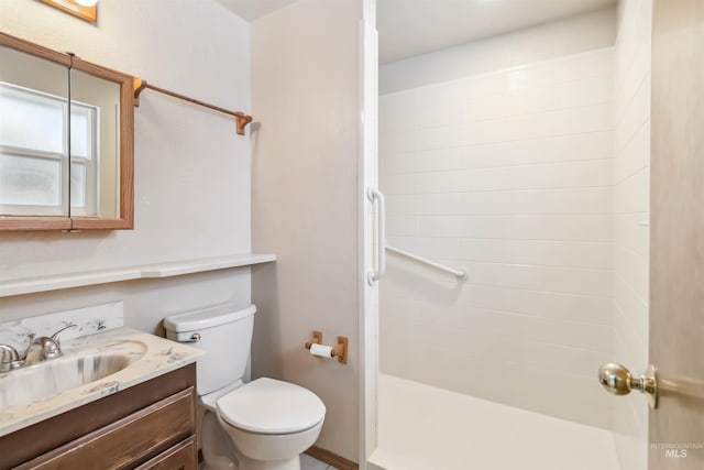 full bathroom featuring toilet, a stall shower, and vanity