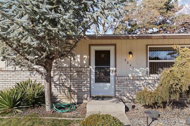 view of exterior entry with brick siding