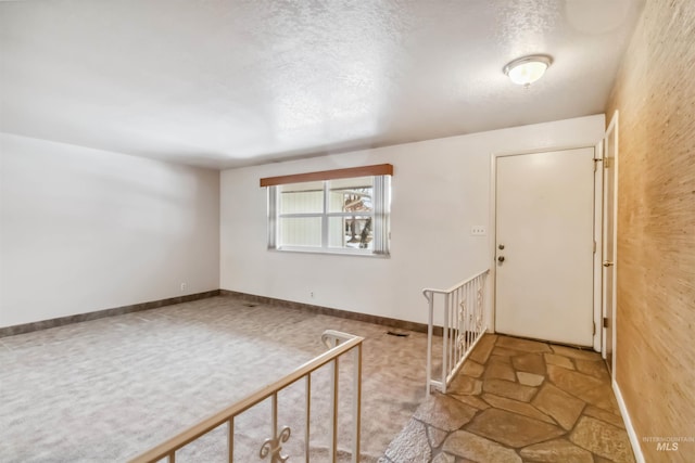 entrance foyer featuring visible vents, baseboards, and a textured ceiling