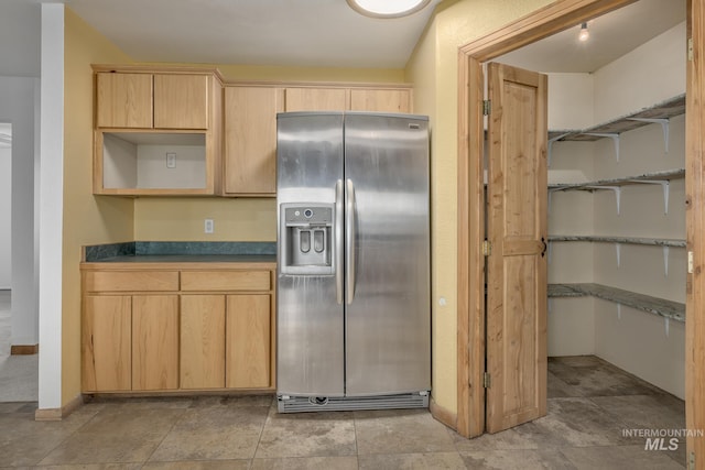 kitchen featuring light brown cabinetry and stainless steel fridge