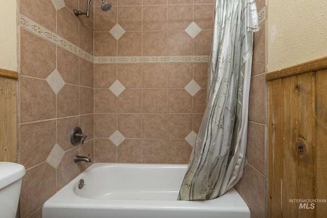 bathroom featuring shower / bath combination with curtain and toilet