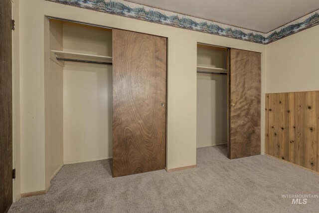 bathroom with curtained shower, wood walls, vanity, and toilet