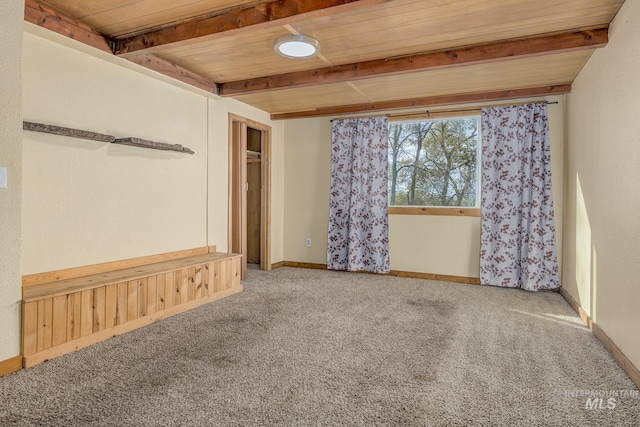 carpeted spare room featuring wood ceiling and beam ceiling