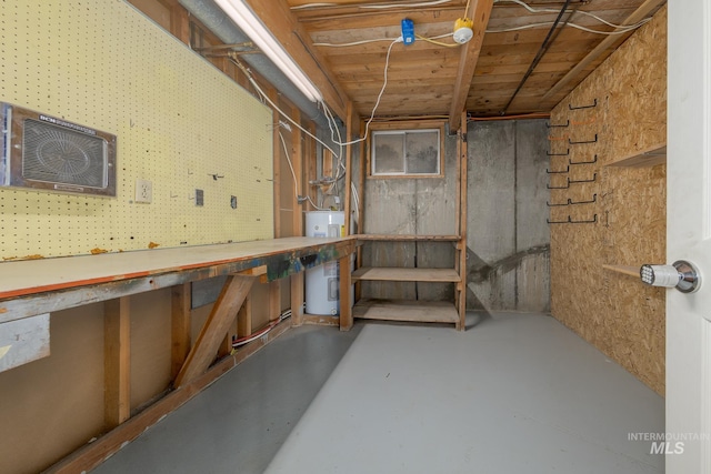 basement with a workshop area, water heater, and a wall mounted air conditioner