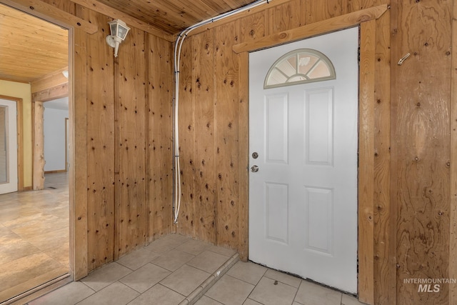 entryway featuring wood ceiling, wooden walls, and light tile patterned floors