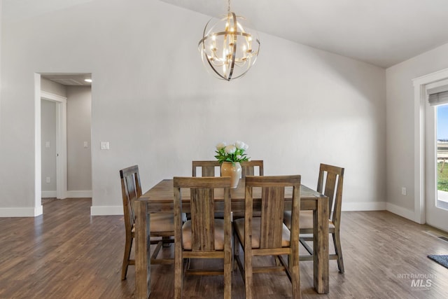 dining space featuring wood finished floors, baseboards, and an inviting chandelier