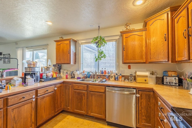 kitchen with sink, a textured ceiling, and stainless steel appliances