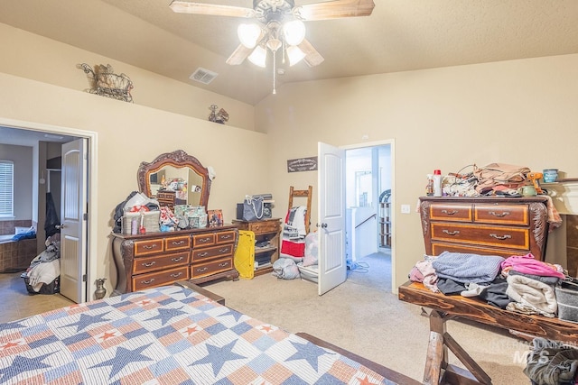 carpeted bedroom with ceiling fan, lofted ceiling, and ensuite bath