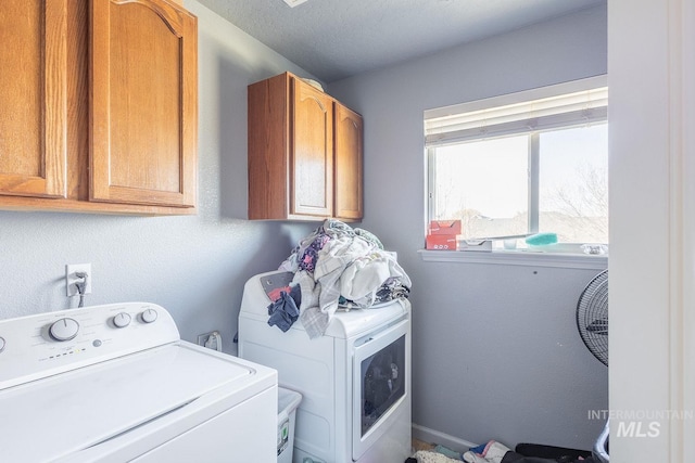 laundry area featuring washer and dryer, cabinets, and a textured ceiling