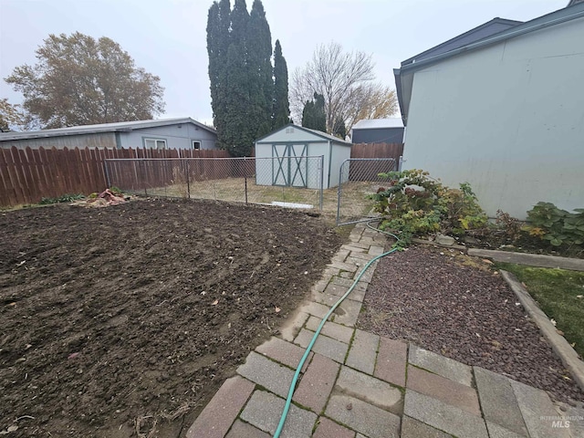 view of yard with a fenced backyard, an outdoor structure, and a storage shed