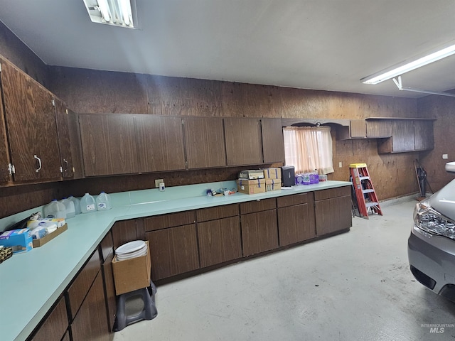 kitchen with light countertops, concrete floors, and dark brown cabinetry