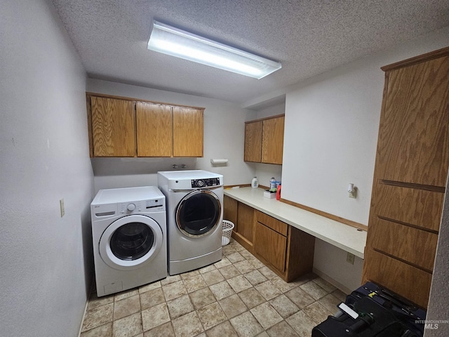 laundry room with cabinet space, a textured ceiling, and separate washer and dryer