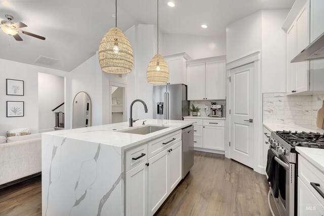 2935 NW 8th Ave, Meridian, ID 83646 - kitchen with a sink, appliances with stainless steel finishes, vaulted ceiling, open floor plan, and tasteful backsplash