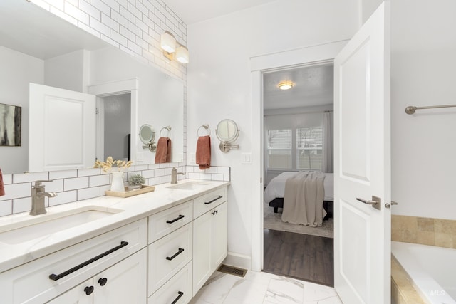 2935 NW 8th Ave, Meridian, ID 83646 - full bath with double vanity, backsplash, a tub, marble look tiles, and ensuite bath