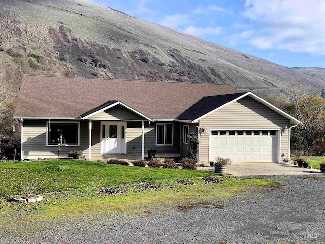 ranch-style house featuring a garage and a front lawn