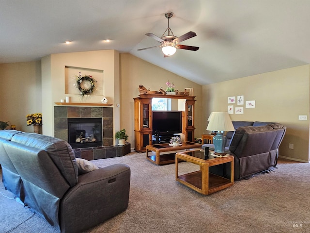 carpeted living room featuring lofted ceiling, a tile fireplace, and ceiling fan