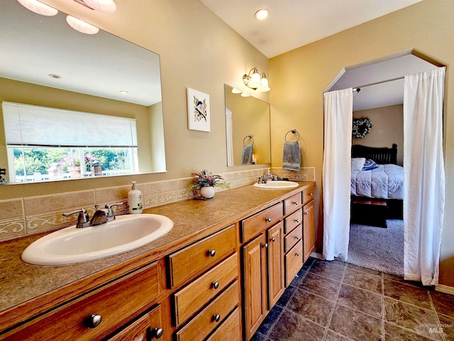 bathroom with tile floors, tasteful backsplash, oversized vanity, and dual sinks