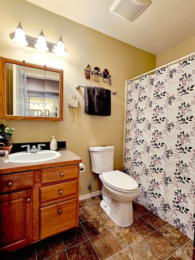 bathroom with vanity, toilet, and tile floors