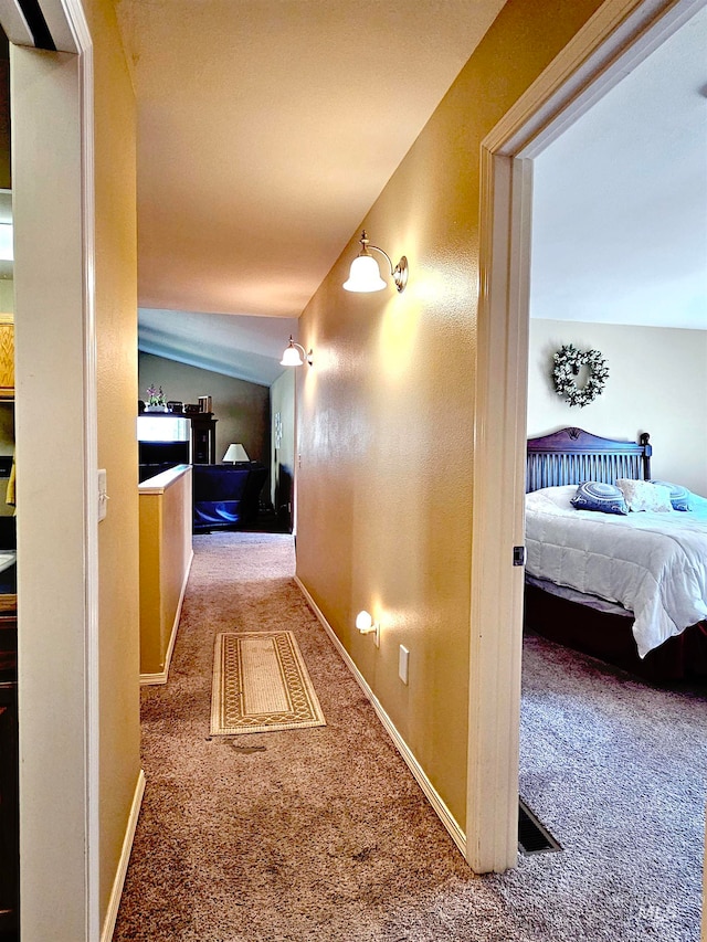 corridor with carpet and vaulted ceiling