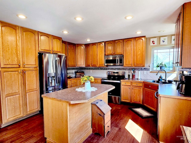 kitchen with dark hardwood / wood-style flooring, a kitchen island, tasteful backsplash, appliances with stainless steel finishes, and sink