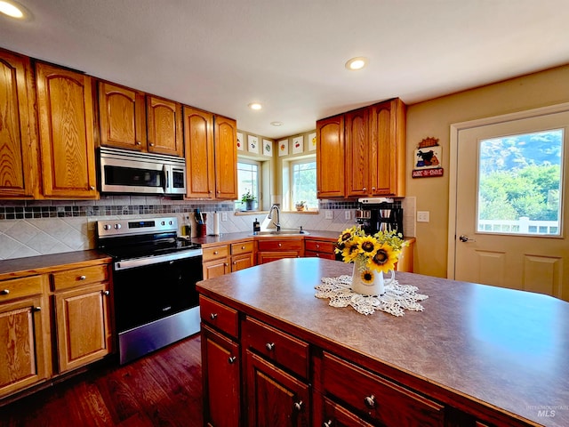 kitchen featuring sink, dark wood-type flooring, backsplash, and appliances with stainless steel finishes