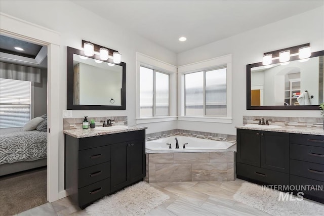 bathroom with vanity and tiled bath