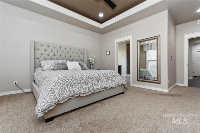 bedroom featuring ceiling fan, a raised ceiling, and carpet