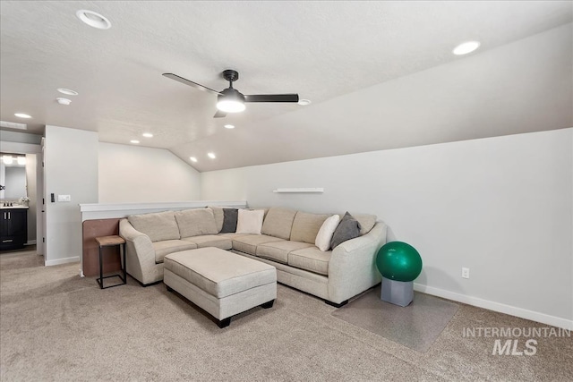 carpeted living room featuring ceiling fan, vaulted ceiling, and a textured ceiling