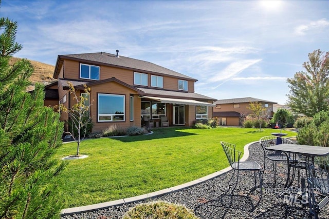 rear view of house with a yard and a patio area