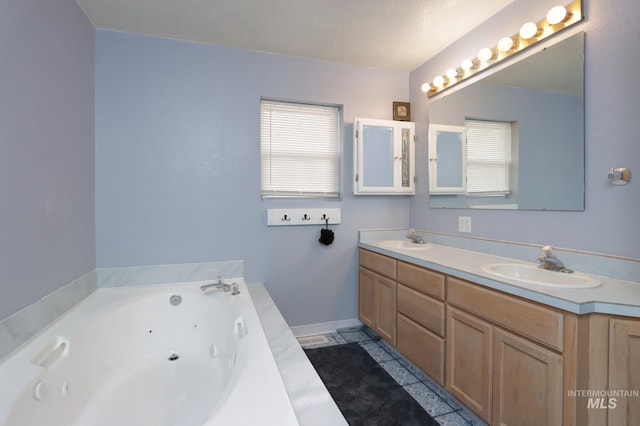 full bath with double vanity, a tub with jets, baseboards, and a sink