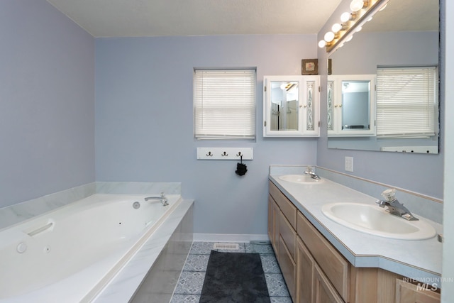 bathroom featuring double vanity, a whirlpool tub, baseboards, and a sink