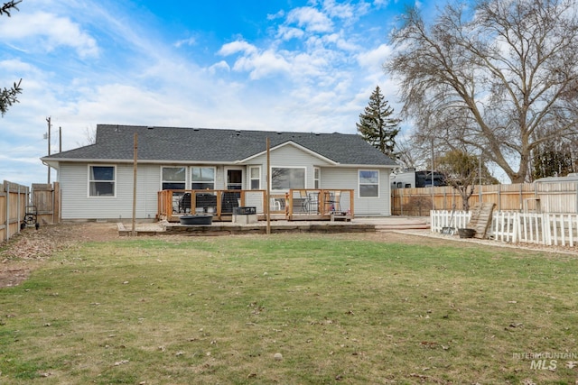 back of property featuring a wooden deck, a lawn, and a fenced backyard