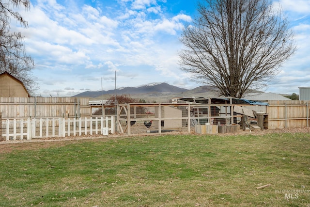 view of yard with a mountain view, an outdoor structure, exterior structure, and fence