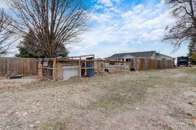 view of yard featuring an outdoor structure, fence, and exterior structure