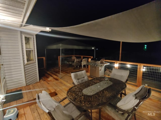 patio at twilight featuring grilling area and outdoor dining space