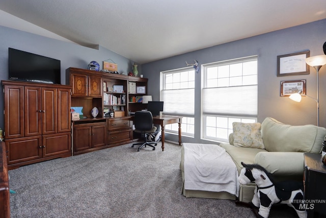 carpeted home office featuring lofted ceiling