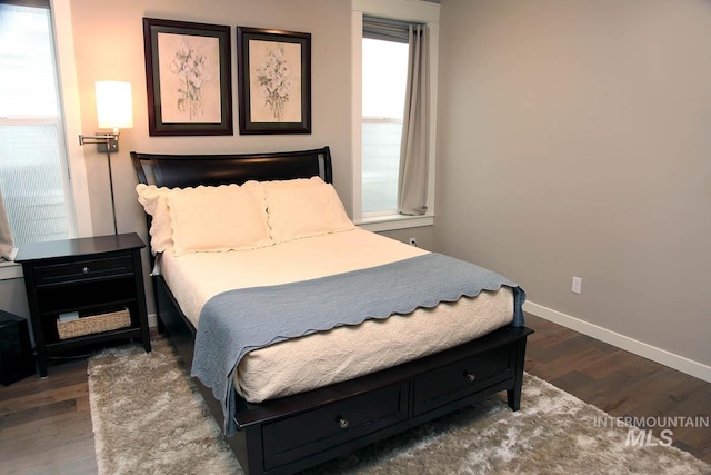 bedroom with dark wood-style floors and baseboards