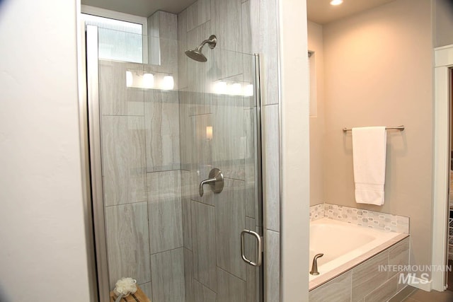 full bathroom with a shower stall and a garden tub