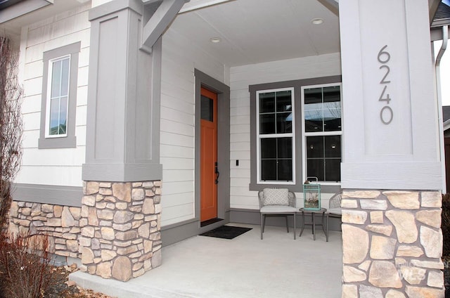 property entrance featuring a porch and stone siding