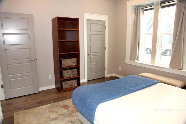 bedroom featuring multiple windows, wood finished floors, and baseboards