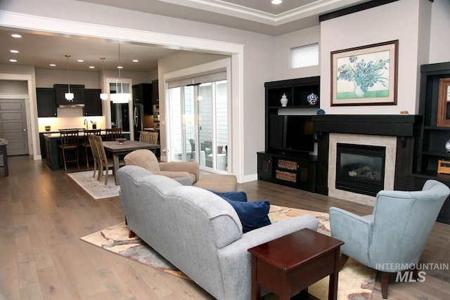 living room with recessed lighting, wood finished floors, and a fireplace