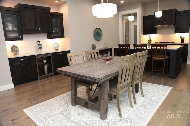 dining space featuring wine cooler, recessed lighting, baseboards, and light wood finished floors