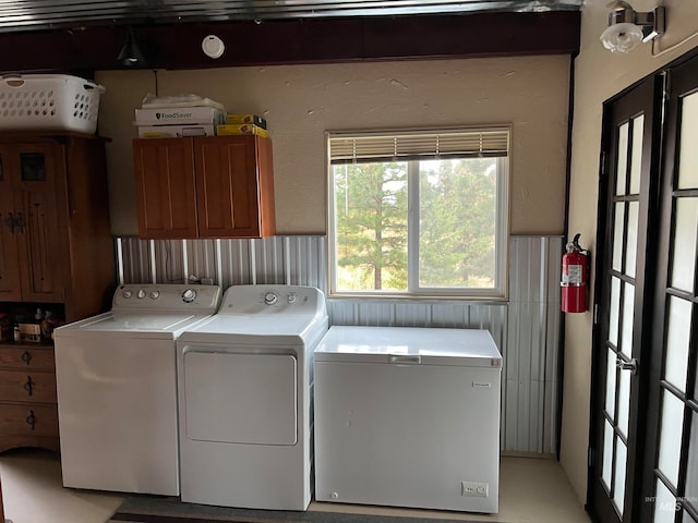 laundry area featuring washer and clothes dryer and cabinets